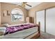 Comfortable bedroom featuring a ceiling fan, arched window, and closet with sliding doors at 94 Fantasia Ln, Henderson, NV 89074