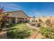 Landscaped backyard with patio furniture, green grass, and privacy fence at 10126 Cliff Dwellings Ave, Las Vegas, NV 89178