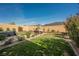 Landscaped backyard features lawn, flower beds, and covered hot tub at 10126 Cliff Dwellings Ave, Las Vegas, NV 89178