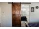 Bedroom view of sliding barn door leading into en suite bathroom with vanity at 10126 Cliff Dwellings Ave, Las Vegas, NV 89178