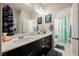 Bright bathroom boasts double sinks, a black vanity, and framed mirrors at 10126 Cliff Dwellings Ave, Las Vegas, NV 89178