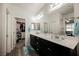 Bathroom with double vanity sinks, light fixtures, and a view into the walk-in closet at 10126 Cliff Dwellings Ave, Las Vegas, NV 89178