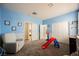 Bright bedroom with a play area, including a slide and a closet, and a comfortable armchair at 10126 Cliff Dwellings Ave, Las Vegas, NV 89178