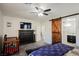Bedroom featuring an en suite bathroom with a barn door, vanity and mounted TV at 10126 Cliff Dwellings Ave, Las Vegas, NV 89178