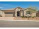 Inviting single-story home with a two-car garage, desert landscaping and dark-colored front door at 10126 Cliff Dwellings Ave, Las Vegas, NV 89178