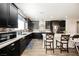 Stylish kitchen featuring dark cabinets, stainless steel appliances, and a breakfast bar at 10126 Cliff Dwellings Ave, Las Vegas, NV 89178