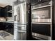 Close-up of stainless steel refrigerator and double ovens in modern kitchen with black cabinetry at 10126 Cliff Dwellings Ave, Las Vegas, NV 89178