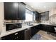 Well-equipped kitchen with sleek black cabinets, stainless steel appliances, and white countertops at 10126 Cliff Dwellings Ave, Las Vegas, NV 89178
