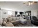 Bright and airy living room featuring a large sectional sofa, ceiling fan, and adjacent kitchen at 10126 Cliff Dwellings Ave, Las Vegas, NV 89178