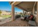 A covered patio with brick flooring has ceiling fans, seating, and a hot tub, creating a relaxing outdoor space at 10126 Cliff Dwellings Ave, Las Vegas, NV 89178