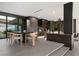 Modern dining area featuring a sleek table, stylish chairs, and a beautiful view of the landscaped backyard at 12 Chisel Crest Ct, Henderson, NV 89012
