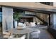Outdoor patio features stylish dining set with lush landscaping, water feature, and seamless access to the open-concept living area at 12 Chisel Crest Ct, Henderson, NV 89012