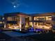 Striking modern home with infinity pool reflecting the moonlight and adjacent outdoor entertainment areas at 12 Chisel Crest Ct, Henderson, NV 89012