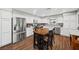 Open concept kitchen with stainless steel appliances, sleek white cabinets, wood table and chairs at 1619 Abby Ave, Henderson, NV 89014
