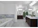 Bright bathroom with a soaking tub with marble surround and double sink vanity at 2209 Purple Majesty Ct, Las Vegas, NV 89117