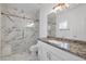 The remodeled bathroom provides marble lined shower and granite counters. The glass doors add a modern touch at 2209 Purple Majesty Ct, Las Vegas, NV 89117