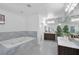 Bright bathroom with a soaking tub with marble surround and double sink vanity at 2209 Purple Majesty Ct, Las Vegas, NV 89117