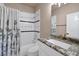 This well-maintained bathroom features a shower-tub combo, tile surround, and a granite countertop at 2209 Purple Majesty Ct, Las Vegas, NV 89117