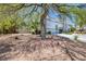 View of the home's front exterior from a mature tree featuring a three car garage and desert landscaping at 2209 Purple Majesty Ct, Las Vegas, NV 89117