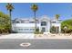 Grand three-car garage beneath a two-story home, enhanced by palm trees and a well-manicured front yard at 2209 Purple Majesty Ct, Las Vegas, NV 89117