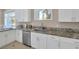 White cabinets, granite countertops, and a stainless dishwasher in this modern kitchen at 2209 Purple Majesty Ct, Las Vegas, NV 89117