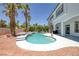 Backyard pool and spa features white coping, palm trees, desert landscaping, and access to the home at 2209 Purple Majesty Ct, Las Vegas, NV 89117