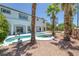 Backyard pool and spa features white coping, desert landscaping, and palm trees at 2209 Purple Majesty Ct, Las Vegas, NV 89117