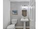 Stylish powder room featuring a pedestal sink and decorative wallpaper at 2209 Purple Majesty Ct, Las Vegas, NV 89117