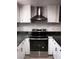 A kitchen featuring stainless steel range hood and oven against white cabinets and black hardware at 3275 Arville St # C, Las Vegas, NV 89102