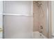 Bathroom shower-tub combo with tan tiling and a semi-frameless glass sliding door at 4176 Skywalker Ave, Las Vegas, NV 89120