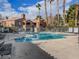 Relaxing community pool featuring lounge chairs, well-kept grounds, and surrounding buildings at 5220 Mission Carmel Ln # 101, Las Vegas, NV 89107