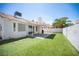 Spacious backyard featuring a covered patio, artificial grass, and a charming desert landscape at 7103 Shadow Crest Dr, Las Vegas, NV 89119