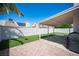 Spacious backyard featuring artificial grass, a covered patio, and a well-kept landscape at 7103 Shadow Crest Dr, Las Vegas, NV 89119