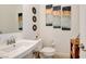 Bright bathroom with a modern sink vanity, toilet, and decorative wall art, creating a welcoming space at 8550 Lost Pony St, Las Vegas, NV 89148