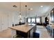 Kitchen island features modern pendant lighting, a sink, and is open to the living and dining area for easy entertaining at 8550 Lost Pony St, Las Vegas, NV 89148