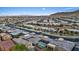 Expansive aerial view showcases the neighborhood's uniform rooftops against a backdrop of mountains and clear blue skies at 10018 Regency Square Ave, Las Vegas, NV 89148