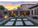 The backyard is a desert paradise with decorative cacti, gravel, and an artificial turf area at 10018 Regency Square Ave, Las Vegas, NV 89148