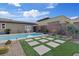 The backyard with its desert theme and cacti blends artificial turf with decorative stones at 10018 Regency Square Ave, Las Vegas, NV 89148