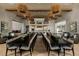 A spacious dining area with long tables, stylish seating, elegant light fixtures, and modern decor at 10018 Regency Square Ave, Las Vegas, NV 89148