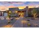 Beautiful single story home with desert landscaping, stone accents, and a brick walkway at sunset at 10018 Regency Square Ave, Las Vegas, NV 89148