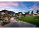Scenic exterior view of community center featuring a pathway, lawn, and mountain views under a colorful sky at 10018 Regency Square Ave, Las Vegas, NV 89148
