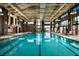 A large indoor swimming pool with ample natural light, lounge chairs, and modern architectural design at 10018 Regency Square Ave, Las Vegas, NV 89148