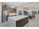 Open-concept kitchen with a large island, stainless steel refrigerator, and adjacent dining area at 10018 Regency Square Ave, Las Vegas, NV 89148