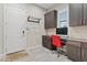 Office featuring built-in desk, cabinets, overhead storage, and door to exterior at 10018 Regency Square Ave, Las Vegas, NV 89148
