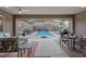Spacious covered patio with tile flooring, comfortable seating, and a dining table overlooking the pool at 10018 Regency Square Ave, Las Vegas, NV 89148