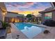 Backyard pool featuring desert landscaping, a basketball hoop, a built-in grill, and colorful evening skies at 10018 Regency Square Ave, Las Vegas, NV 89148