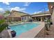 Backyard pool surrounded by desert landscaping, a basketball hoop, a built-in grill, and covered patio seating at 10018 Regency Square Ave, Las Vegas, NV 89148