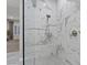 Close-up of a sleek marble-tiled shower with modern fixtures and glass enclosure at 10018 Regency Square Ave, Las Vegas, NV 89148
