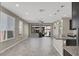 Bright, open-concept living space with tile flooring, recessed lighting, and a sliding door to the backyard at 10976 Bluebell Basin Rd, Las Vegas, NV 89179