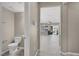 Hallway view of a half-bathroom and open floor plan featuring updated tile flooring and a neutral color palette at 10976 Bluebell Basin Rd, Las Vegas, NV 89179